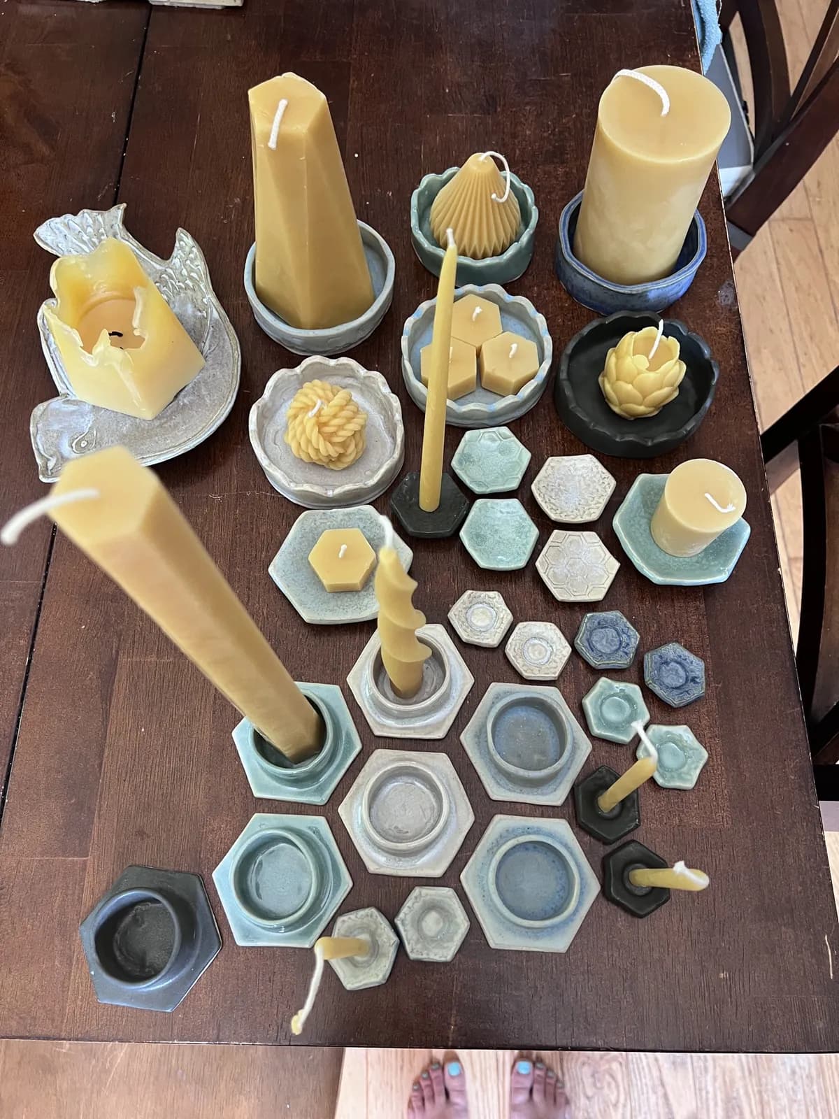 A table full of beeswax candles and hand-thrown ceramics